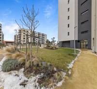 The exterior of an apartment building in Bratislava-Rača on Rudroffova, with modern architecture and landscaped surroundings.