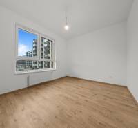 A room in a 3-room apartment with a window and a floor with a wood decor.