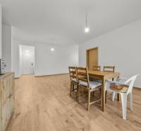 Dining room with a wooden table and chairs, floor with wooden decor, 3-room apartment.