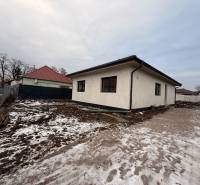A family house in Veľký Grob, with a plot covered with snow and soil, without landscaping.