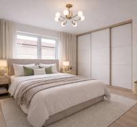 Bright bedroom in a family house with wood-decor flooring and a large bed.