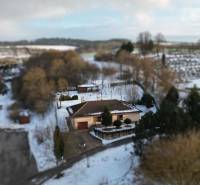 A family house in Myjava surrounded by greenery and a snowy landscape with a view of the surroundings.