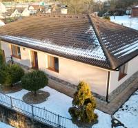 A family house in Myjava with a snow-covered roof and a landscaped garden.