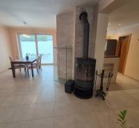 Living room with a fireplace and a dining table in a family house.