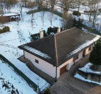 A family house in Myjava with a snowy garden, a shelter, and a nearby road.