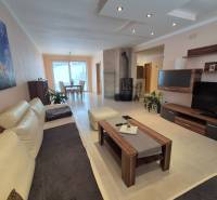 Living room in a family house with a comfortable sofa, fireplace, and furniture in a wooden decor.