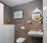 Bathroom with a sink, toilet, round mirror, and decorative painting in a 2-room apartment.