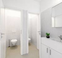 A bright bathroom with two toilets and a sink in the building.