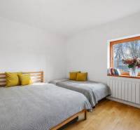 Bedroom in a building with wooden decor, two beds, and window decorations.