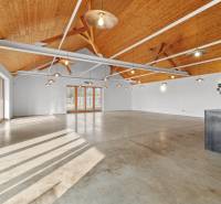 Spacious interior of a building with a wooden ceiling and concrete floor.