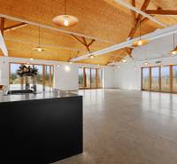 A building with large windows, high ceilings, and wood-patterned flooring.