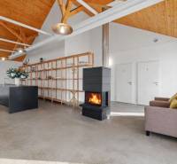 The interior of a building with a fireplace, concrete floor, and wooden ceiling.