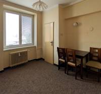 Simple kitchen in a 2-room apartment with a dining table and two chairs.