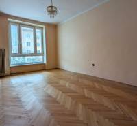 A spacious room in a 2-room apartment with a wood-decor floor and a large window.