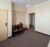 Dining table and chairs in a 2-room apartment with a wooden decor floor.