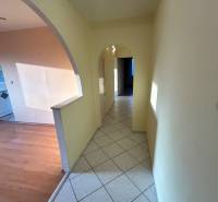 A hallway in a 3-room apartment with an arched entrance and tiles, leading to the rooms.