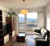 Living room in a two-room apartment with a comfortable sofa and a view from the balcony.
