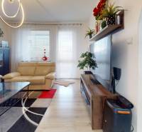 Living room in a 3-room apartment with cream furniture and wooden decor flooring.