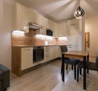 A kitchen in a 2-room apartment with a wooden decor floor and a dining table.