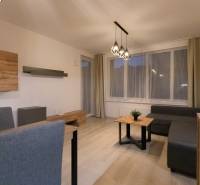 Living room with wood-patterned flooring and gray furniture in a 2-room apartment.