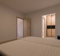 Bedroom with a bed and a wardrobe in a 2-room apartment, floor with a wooden decor.