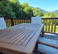 Wooden table and chairs on the terrace of the Cottage with a view of the mountains in Terchová in Vrátňanská.
