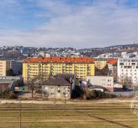 View of Bratislava - Nové Mesto on Budyšínska Street, surrounded by residential buildings and hills.