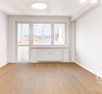 Bright living room with wood-patterned flooring in a 3-room apartment.
