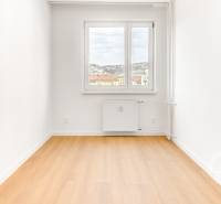 A room in a 3-room apartment with a wooden decor floor and a view from the window.