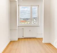 A room in a 3-room apartment with a wooden decor floor and a view from the window.