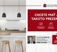 A kitchen with wooden cabinets and an island in a 2-room apartment with modern lighting.