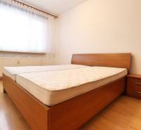 Bedroom in a 3-room apartment with a bed, nightstand, and floor with a wooden decor.