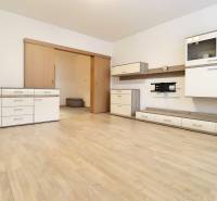 Living room in a 3-room apartment with white furniture and a wooden decor floor.