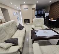 Living room in a family house with a light-colored sofa set and a table on the floor.