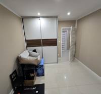 A room in a family house with tiles, a wardrobe, and packaged furniture.