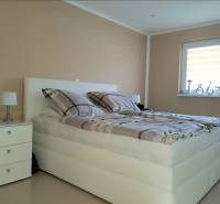 Bright bedroom with a bed, nightstand, and decorations in a family house.