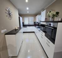 A kitchen in a family house with white cabinets, built-in appliances, and decorative accessories.