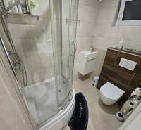 A bathroom in a family house with a bathtub, sink, toilet, and window.