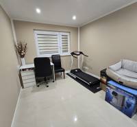 A study in a family house with a writing desk, a treadmill, and a clean white floor.