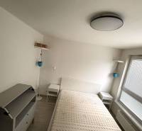 Bright bedroom with bed and furniture, 2-room apartment, floor with wood decor.