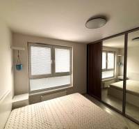 A bedroom in a 2-room apartment with a built-in wardrobe and adjustable blinds on the window.