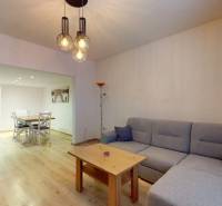 Living room with a sofa and a table, wooden decor flooring, family house.