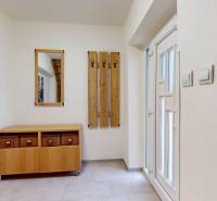 Entrance hallway with a chest of drawers and a mirror in a family house.
