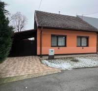 A family house in Dubovce with an orange facade, asphalt road, paving, a slight hint of snow.
