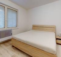 Bedroom in a family house with a bed and a nightstand, floor with wooden decor.