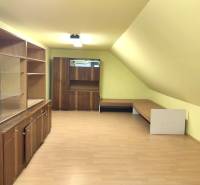 A room in a family house with wooden paneling and a floor with a wooden decor.