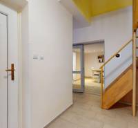 Interior with a wooden staircase, glass doors, and a floor with a wooden decor in a family house.