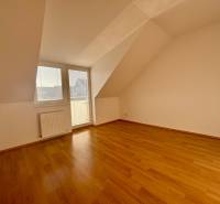 A room in a 2-bedroom apartment with a wooden decor floor and access to a balcony.