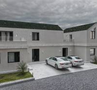 A family house in Mlynica with two white cars in the driveway.