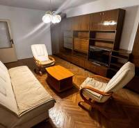 Living room with a sofa, armchairs, furniture, and a wooden decor floor in a two-room apartment.